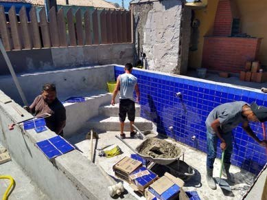 Piscina em construção com equipe trabalhando